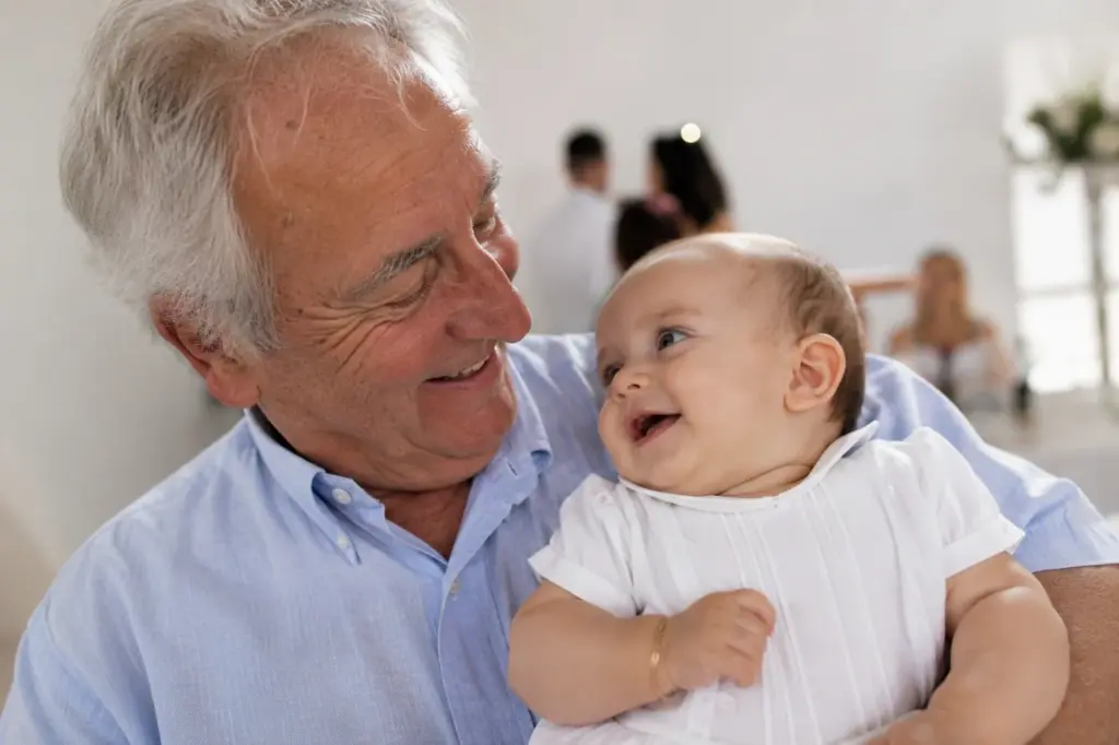 Grand-père complice avec un bébé en tenue de baptême