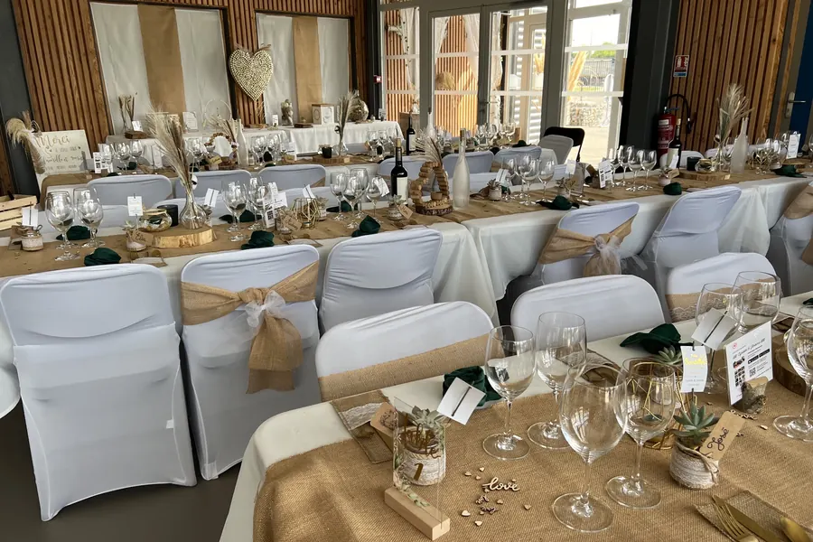 Salle de la Concorde à Bordères-sur-l’Échez dressée pour un mariage champêtre, toile de jute et housses de chaises blanches