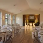 Lettres géantes LOVE lumineuses installées dans une salle de réception de mariage