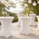 Mange-debout blancs habillés de housses lors d’une réception de mariage en extérieur