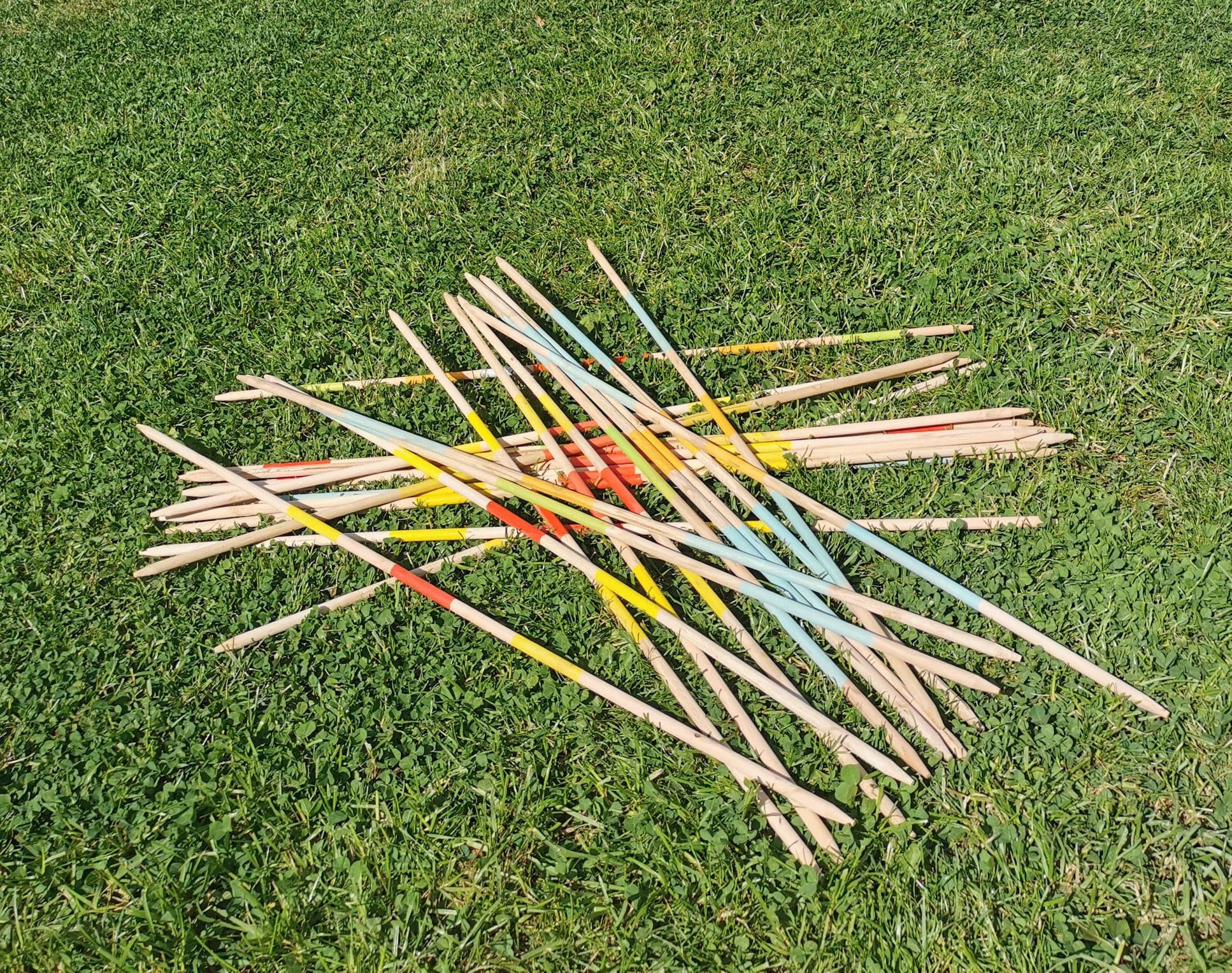 Bâtons colorés dispersés sur l'herbe verte.